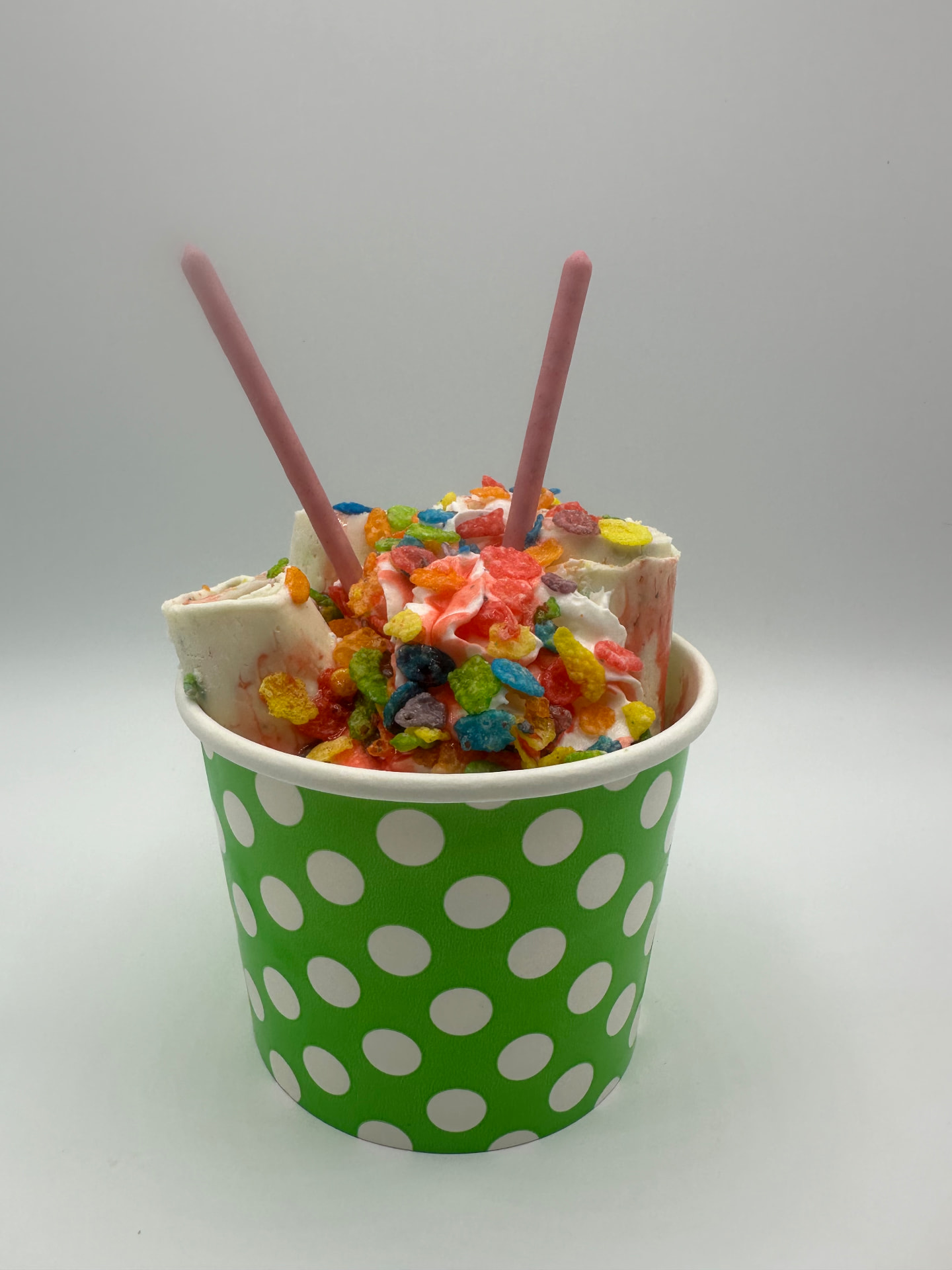 Cereal Burst rolled ice cream in a green polka-dot cup topped with colourful fruity cereal
